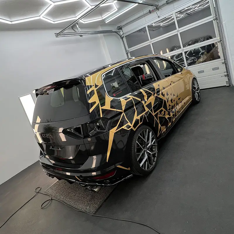 VW Touran Vollfolierung in gold, Teilfolierung schwarz, Designfolierung